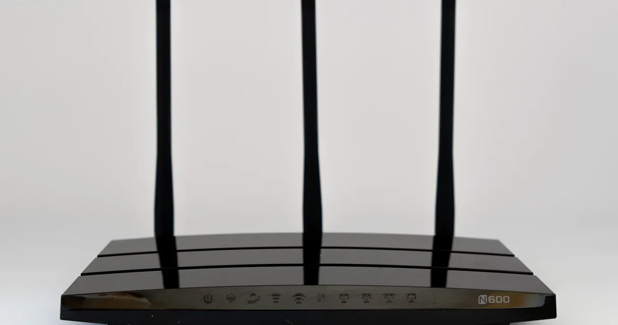 Roteador preto com três antenas sobre fundo claro, ilustrando o IPTV no Wi-Fi de 5 GHz