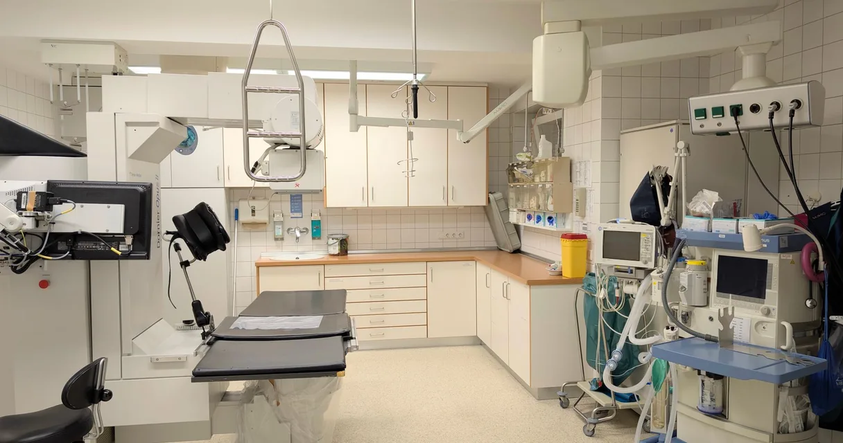 Sala de exames de hospital com mesa e equipamentos, ilustrando o laudo de ressonância da coluna